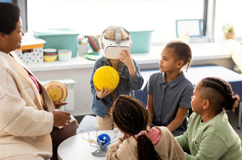 Une ATSEM est en compagnie de 5 enfants âgés de 4 à 6 ans en plein travaux de leçon de choses. 